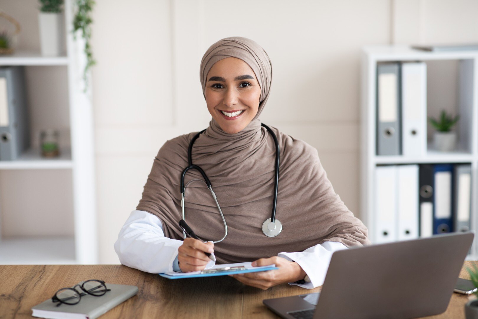 smiling-woman-doctor-in-hijab-taking-anamnesis-in-2025-03-31-07-31-50-utc (Custom)